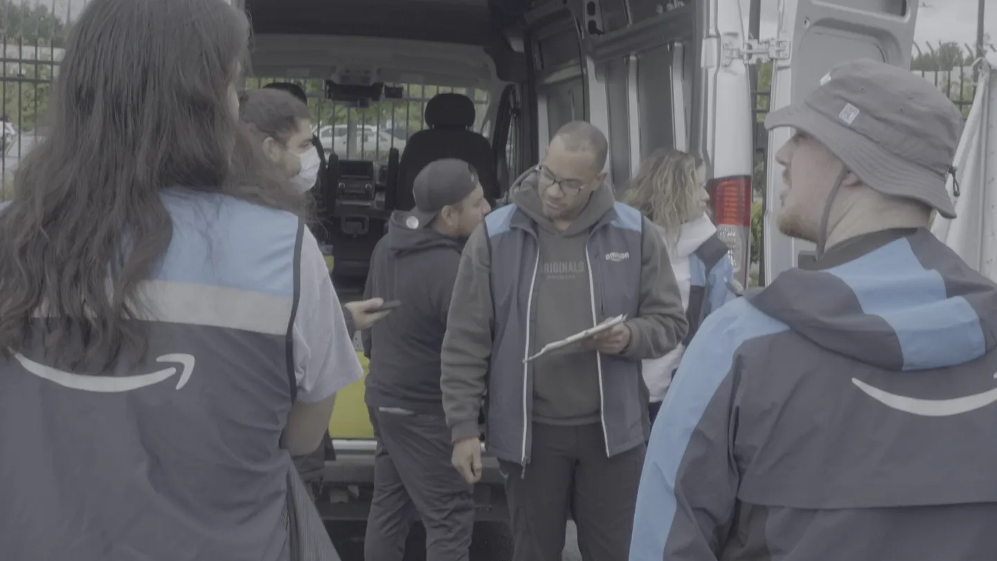 Eagles Routes team members gathered beside a delivery van during a team briefing.